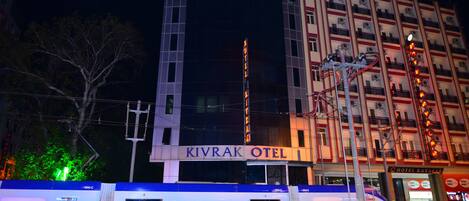 Un hôtel appelé «
Kivrak Hotel
», doté d’une architecture moderne, se distingue par une enseigne verticale bien visible et de nombreux balcons.