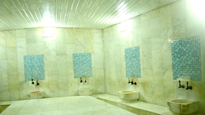 A bathroom with three sinks, a large bathtub, and tiled walls. - Kıvrak Hotel (Antalya)