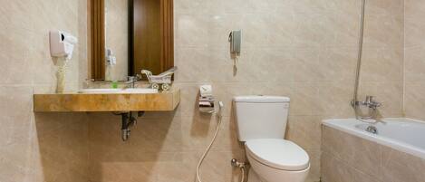 Une salle de bain avec un lavabo, des toilettes et une baignoire.