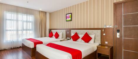 Habitación de hotel con dos camas, suelo de madera, un ventanal con cortinas, un cuadro colgado en la pared y una puerta con pomo.