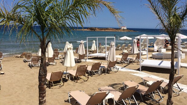 A beach with sun loungers, umbrellas, and a view of the sea. - Artemis Bay by Estia (Hersonissos)