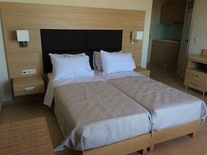 Ein Doppelbett mit Holzbettgestell und Kopfteil, zwei Nachttische, ein Nachtlicht und eine Wandleuchte.