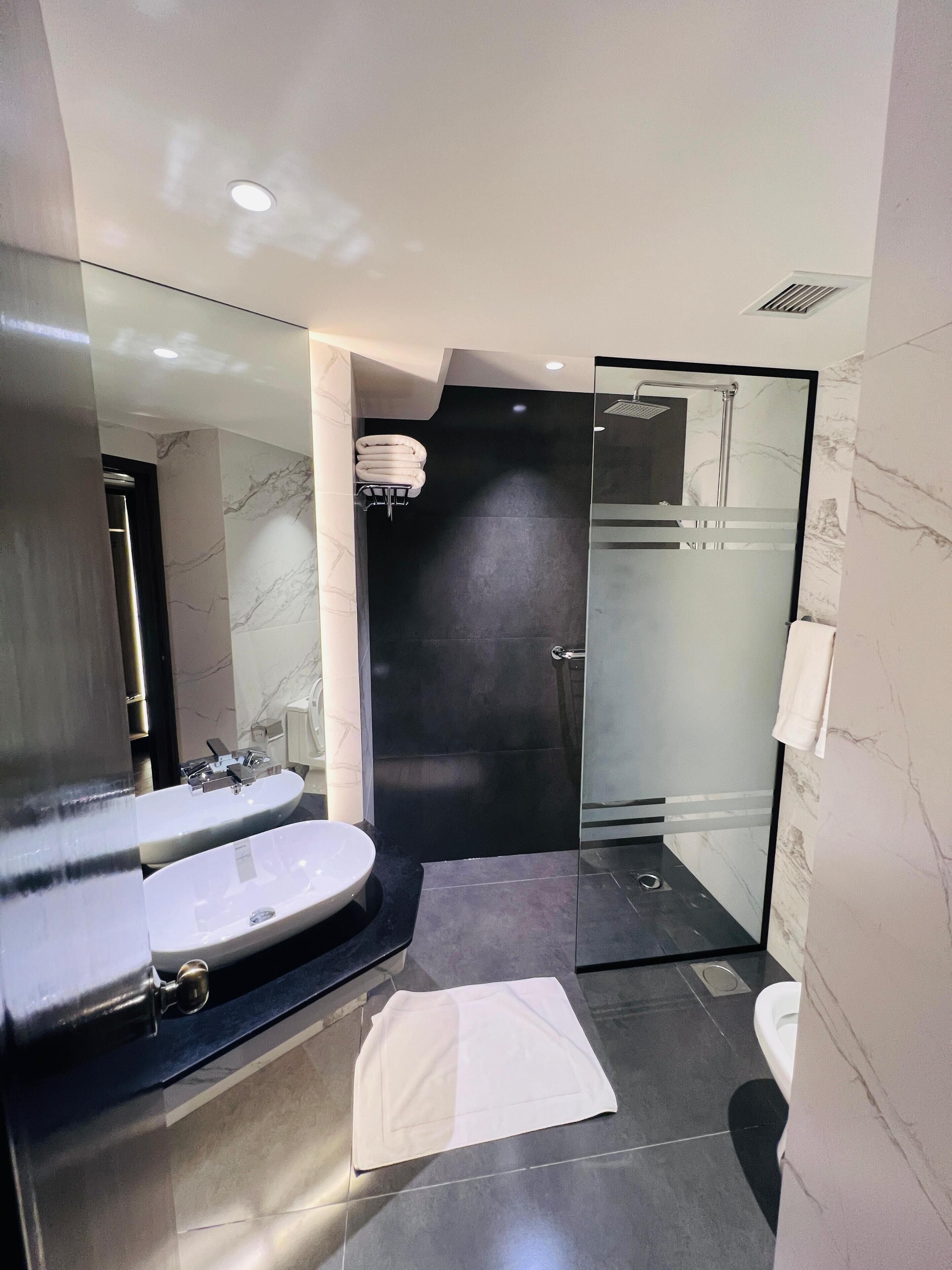 Une salle de bain moderne avec deux lavabos, une douche à l’italienne et des toilettes.