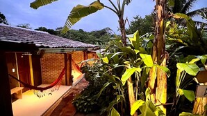 A brick building with a tiled roof, a red rope barrier, and a hammock. - Biribandos Rooms by Trancoso House (Porto Seguro)