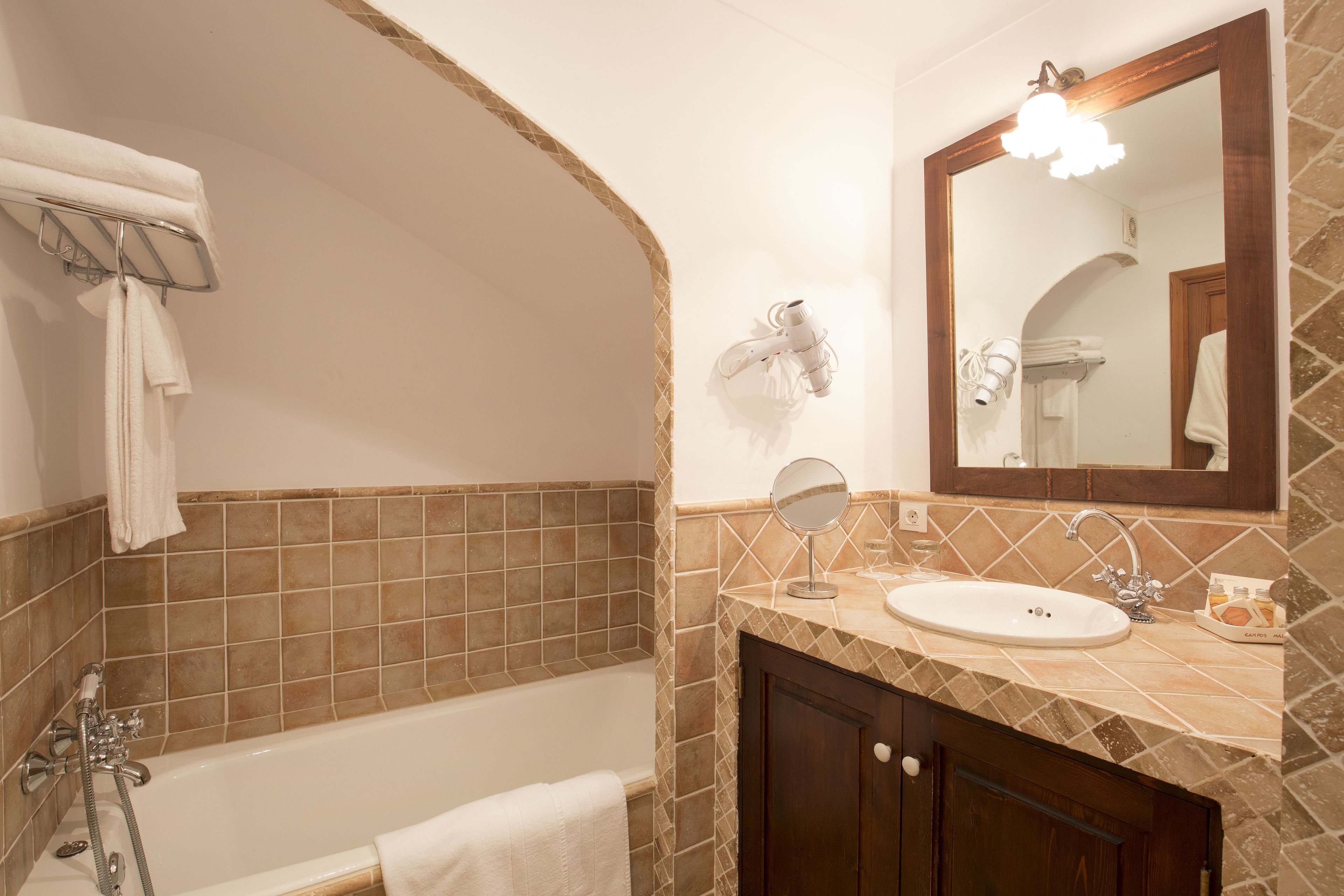 Une salle de bain équipée d’une baignoire, d’un lavabo, d’un miroir et d’un porte-serviettes.