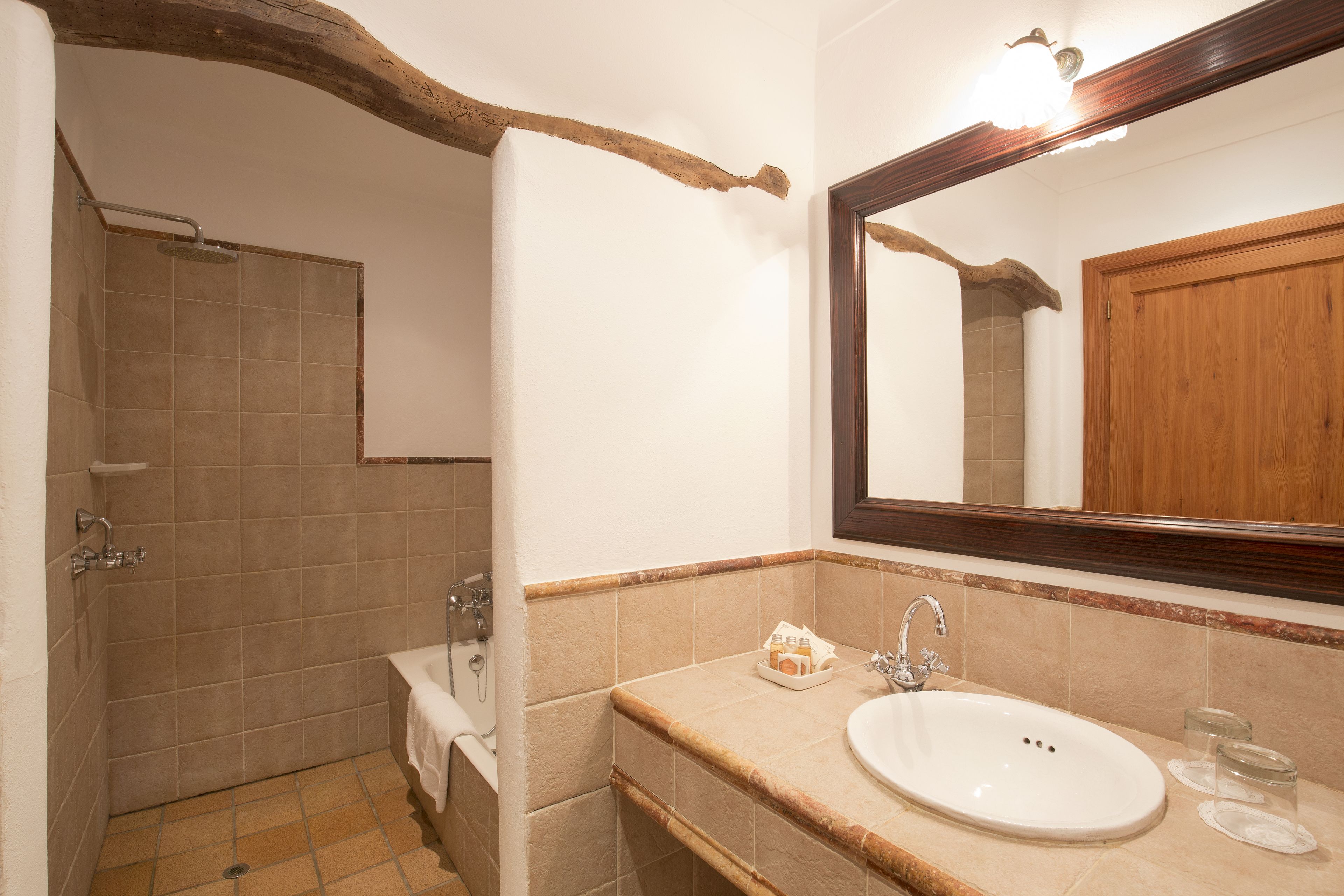 A bathroom with a shower, a sink, and a mirror.