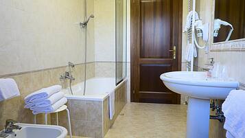 Une salle de bain avec une baignoire, un lavabo et un bidet.