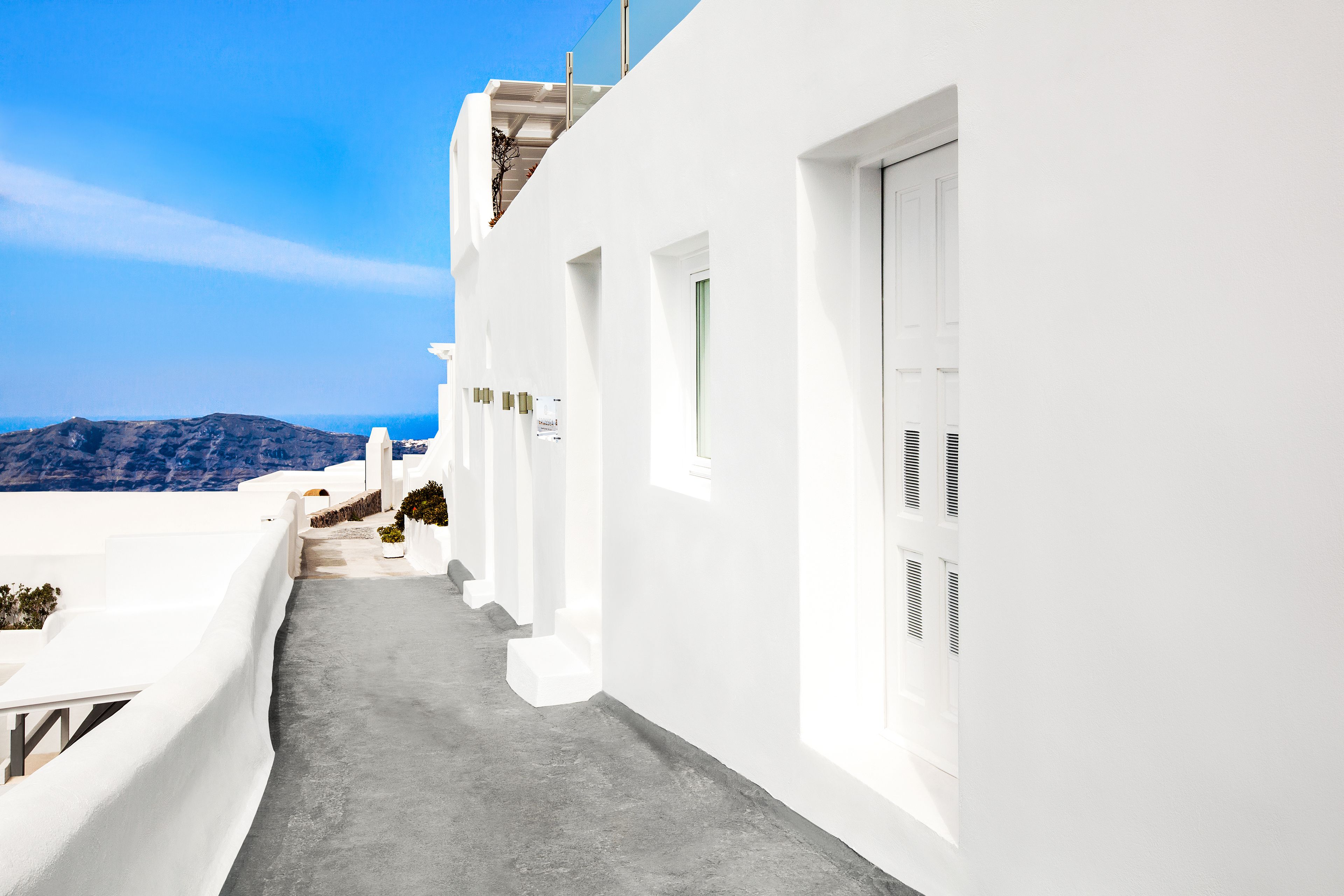 Un bâtiment blanc avec un étroit sentier menant à une porte.