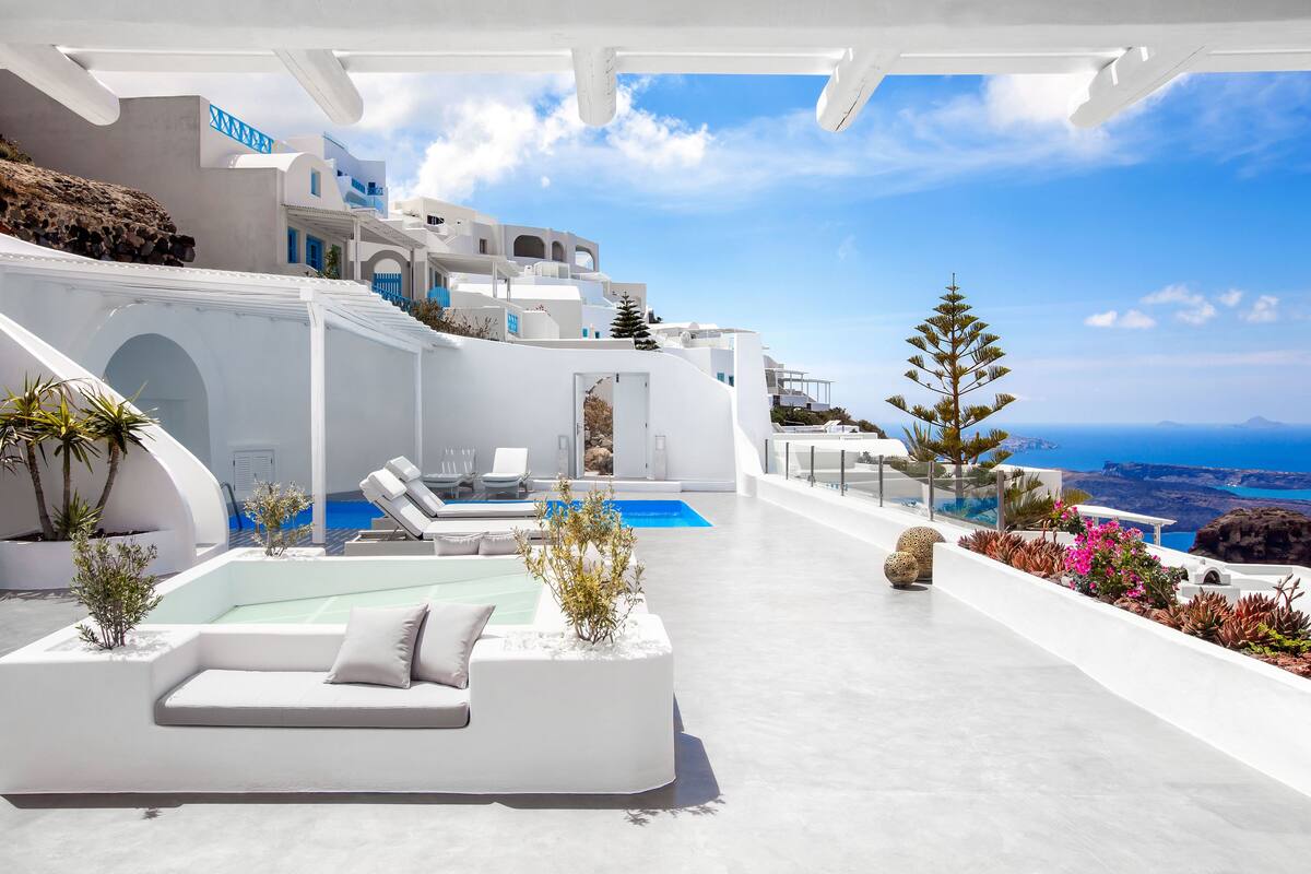 Ein modernes, weißes Gebäude mit Pool, Außenbereich und Meerblick.