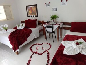 Habitación de hotel con dos camas, una mesa de comedor y una silla.