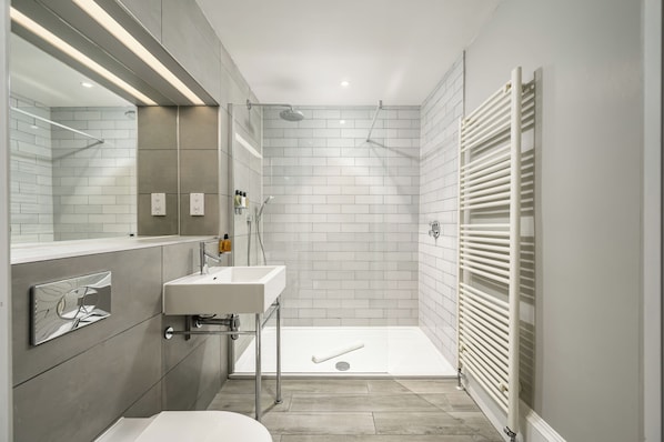 Une salle de bain moderne équipée d’une douche, d’un lavabo et de toilettes.