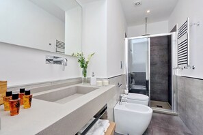 Une salle de bain moderne avec un grand lavabo, des toilettes et une douche à l’italienne.