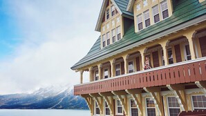 Un immeuble à plusieurs étages doté d’un balcon, de grandes fenêtres et d’un toit végétalisé.
