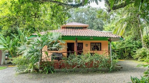 A small, single-story building with a tiled roof, surrounded by dense tropical vegetation. - La Diosa Nature Lodge (Cahuita)