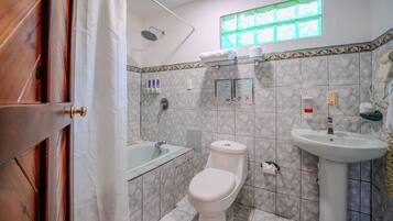 A bathroom with a toilet, sink, and shower.