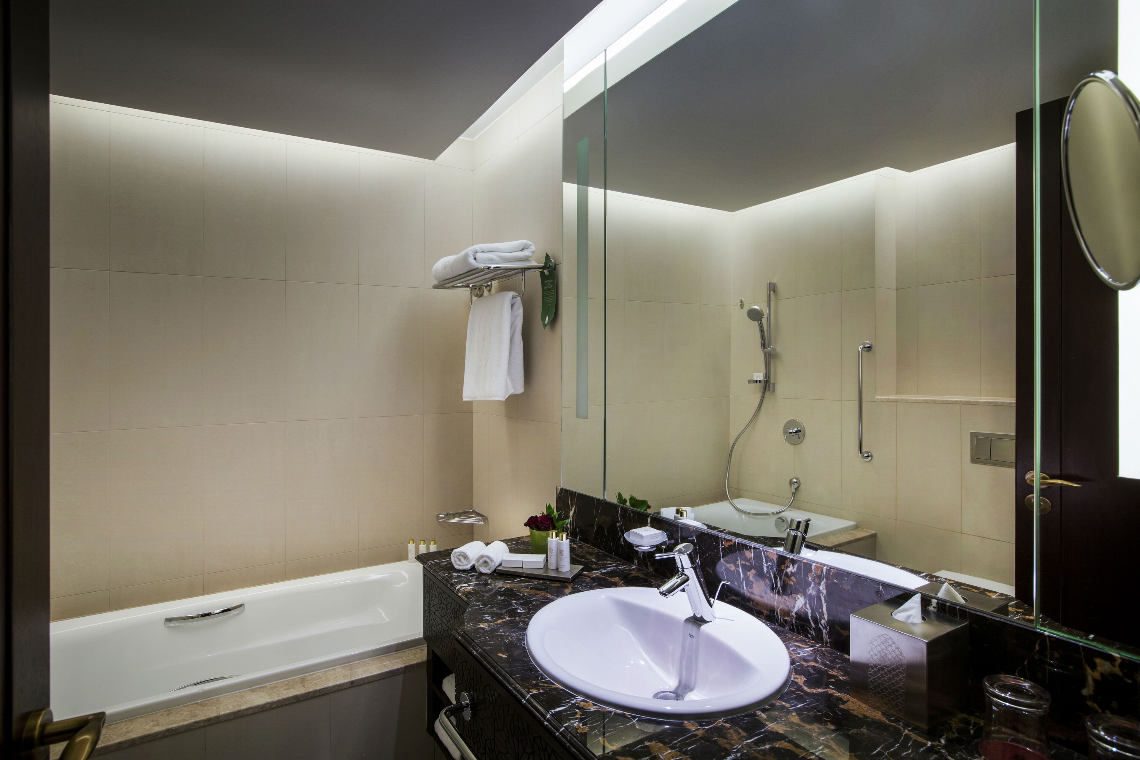 Een moderne badkamer met een bad, een wastafel en een grote spiegel.