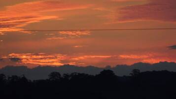 Un coucher de soleil avec une ligne électrique qui traverse le ciel.