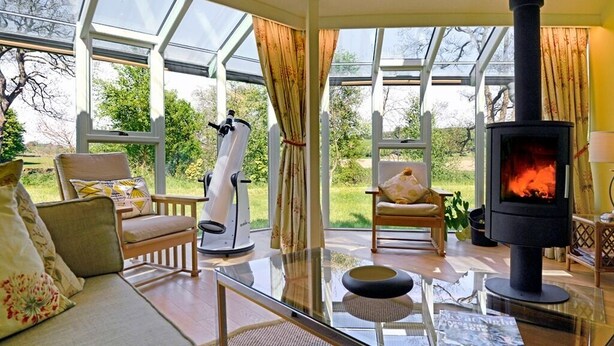 A cozy living room with a glass coffee table, a sofa, and a fireplace. - Black Burn Lodge (Newcastleton)