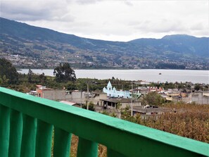 A coastal town with a prominent church, a body of water, and surrounding hills. - Green House Araque Inn (San Pablo del Lago)