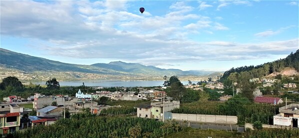 A town with a prominent church, a lake, and mountains in the background. - Green House Araque Inn (San Pablo del Lago)