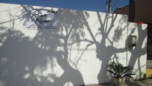 Pared blanca con el logotipo e información de contacto de 'Kama Kama'.