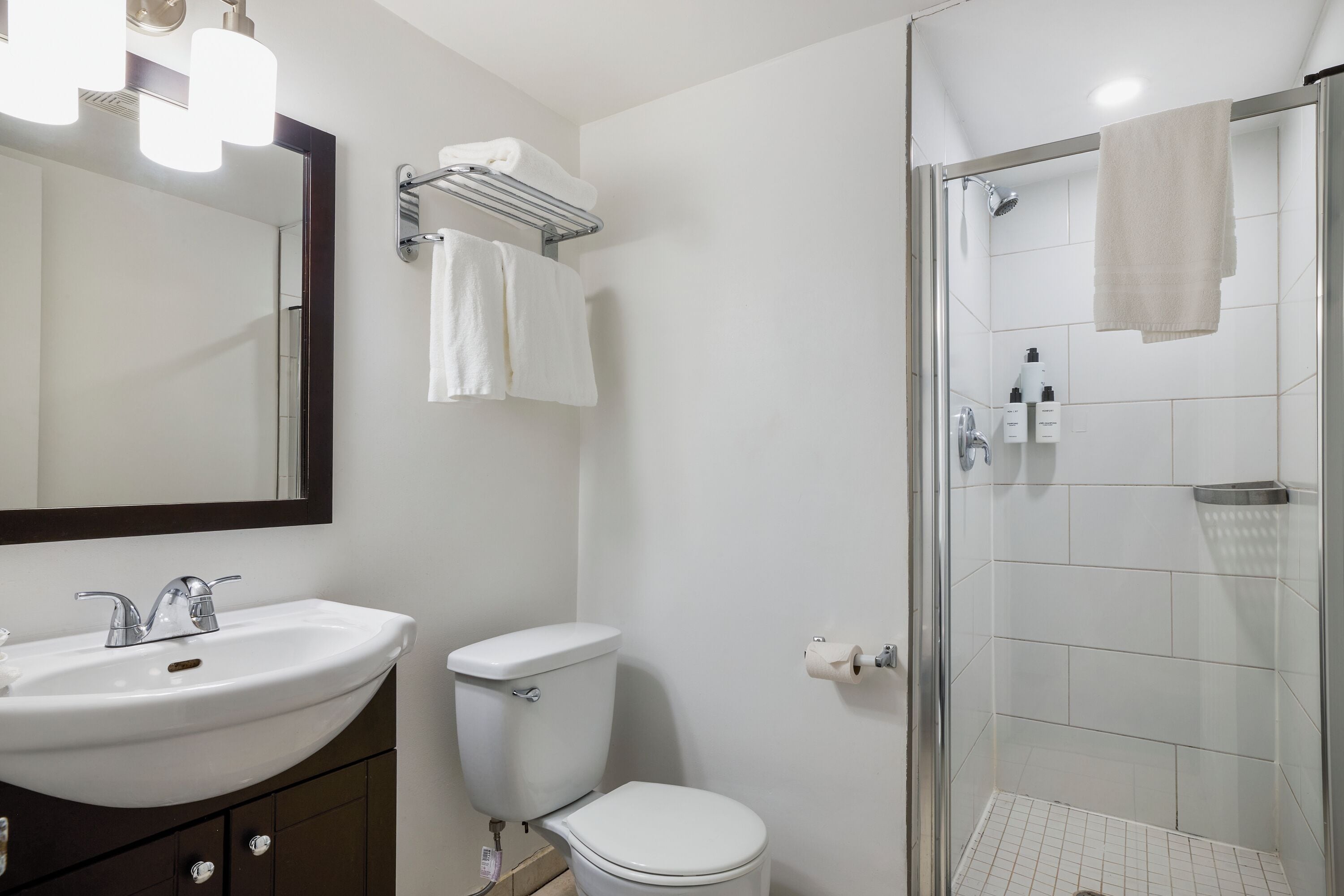 Un baño con lavamanos, inodoro y ducha.