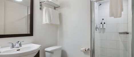 Un baño con lavamanos, inodoro y ducha.