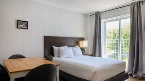 Een hotelkamer met een bed, een bureau en een stoel.