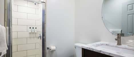 A bathroom with a shower, toilet, and sink.
