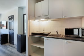 Escritorio, cortinas blackout y tabla de planchar con plancha