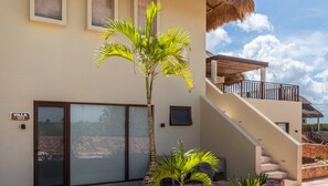 A villa with a staircase, a palm tree, and a thatched roof structure. - Grand Marina Hotel (Telchac Puerto)