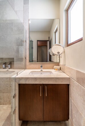 A bathroom with a marble sink, a wooden cabinet, a mirror, and a window. - Grand Marina Hotel (Telchac Puerto)