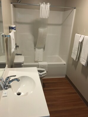 A bathroom with a white sink, toilet, and shower area. - Rolling Hills Lodge (Cherokee)