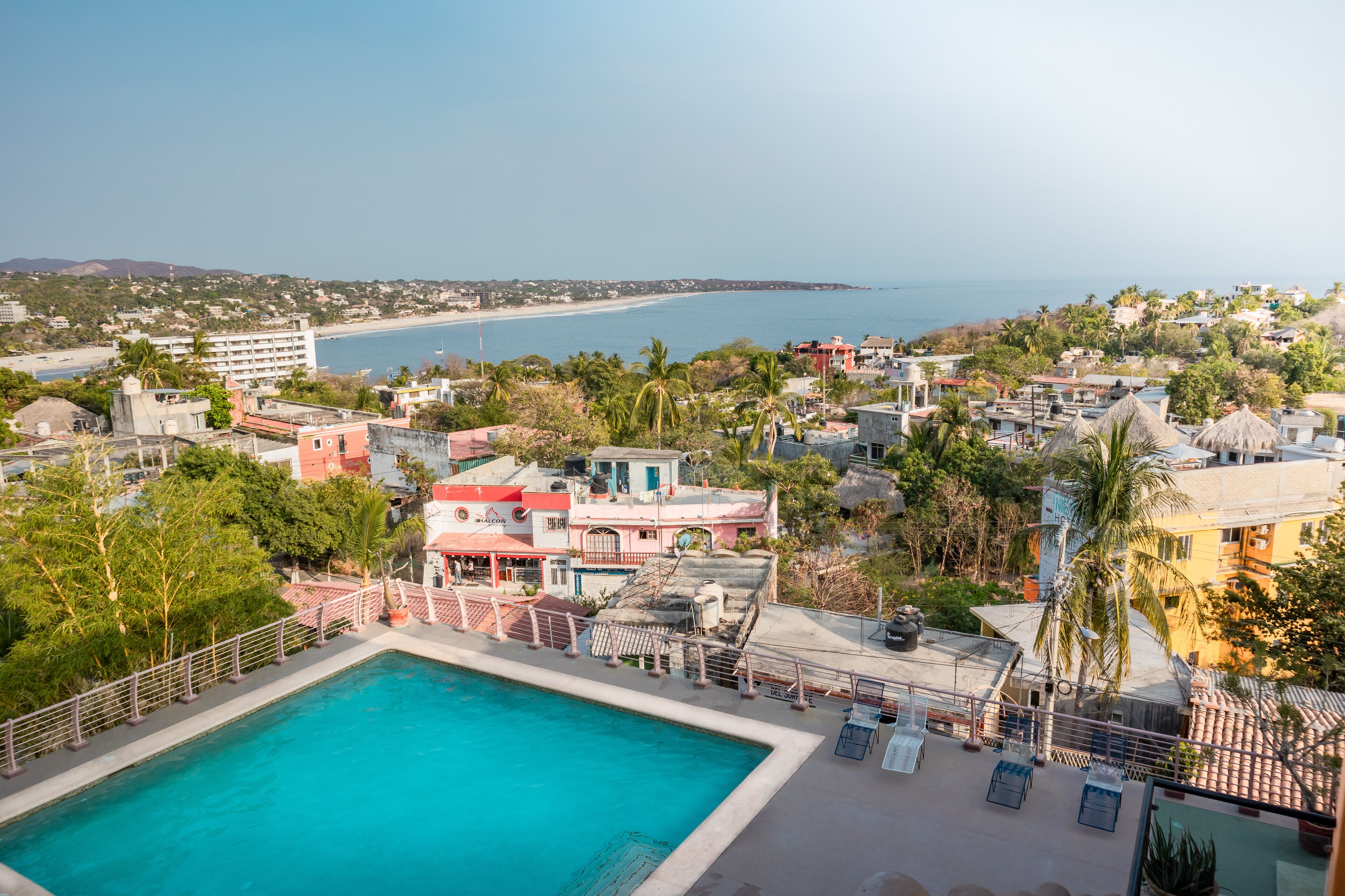 Zona de piscina con vista a la playa y al océano.
