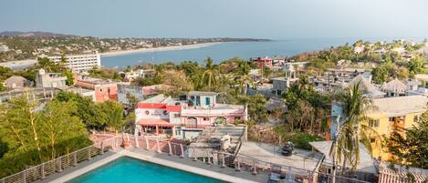Zona de piscina con vista a la playa y al océano.
