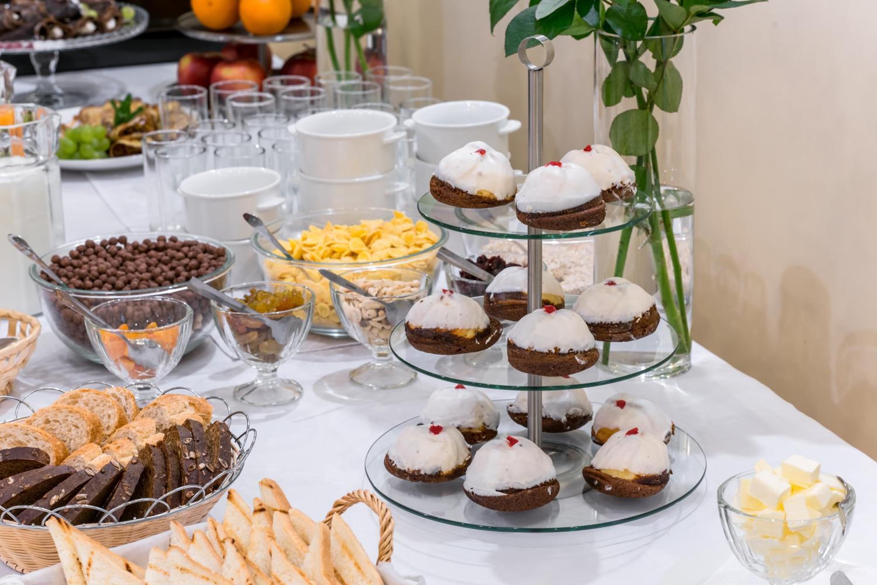 Een buffet met verschillende soorten eten, zoals brood, gebak en desserts.