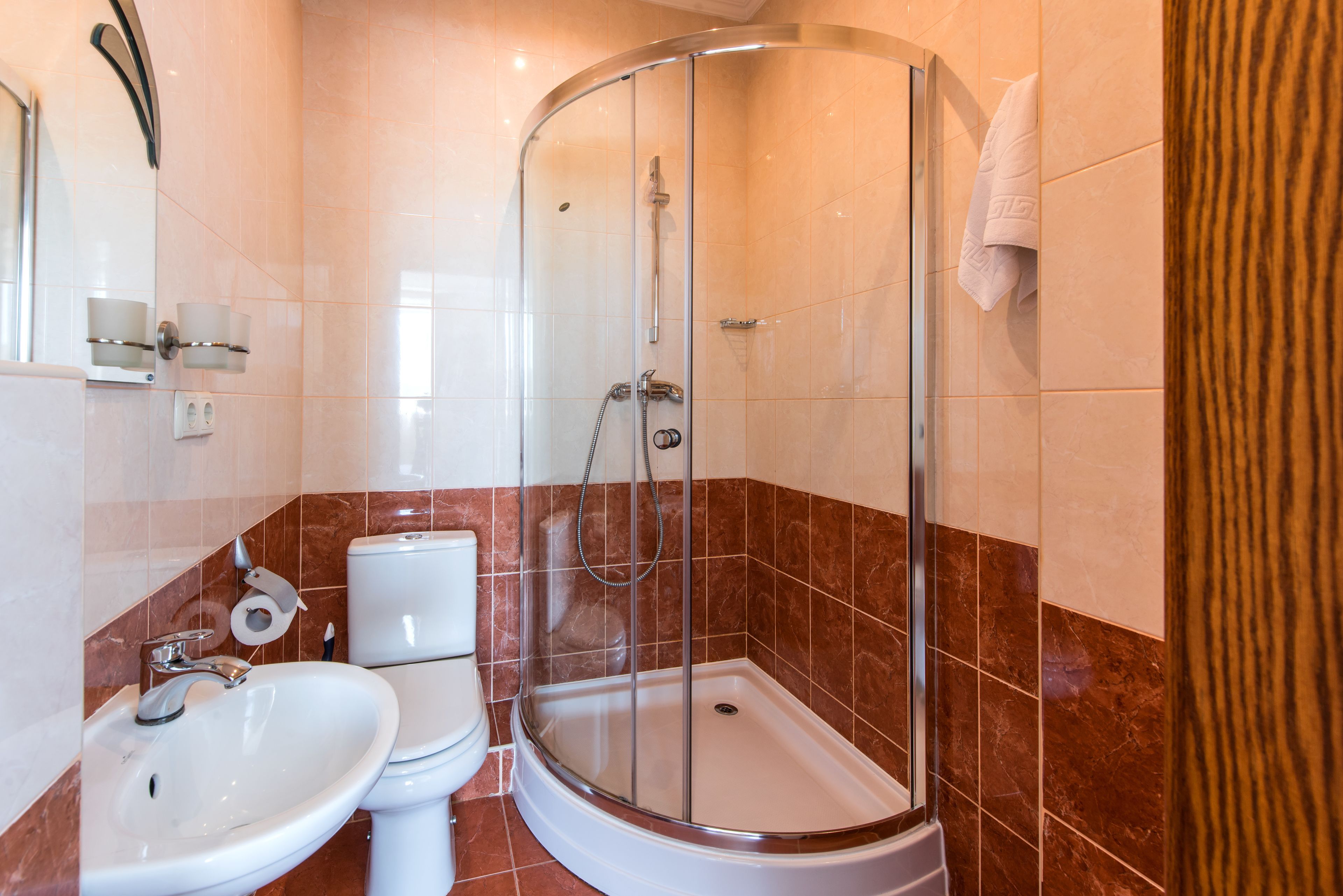 Een badkamer met een douchecabine, een wastafel en een toilet.