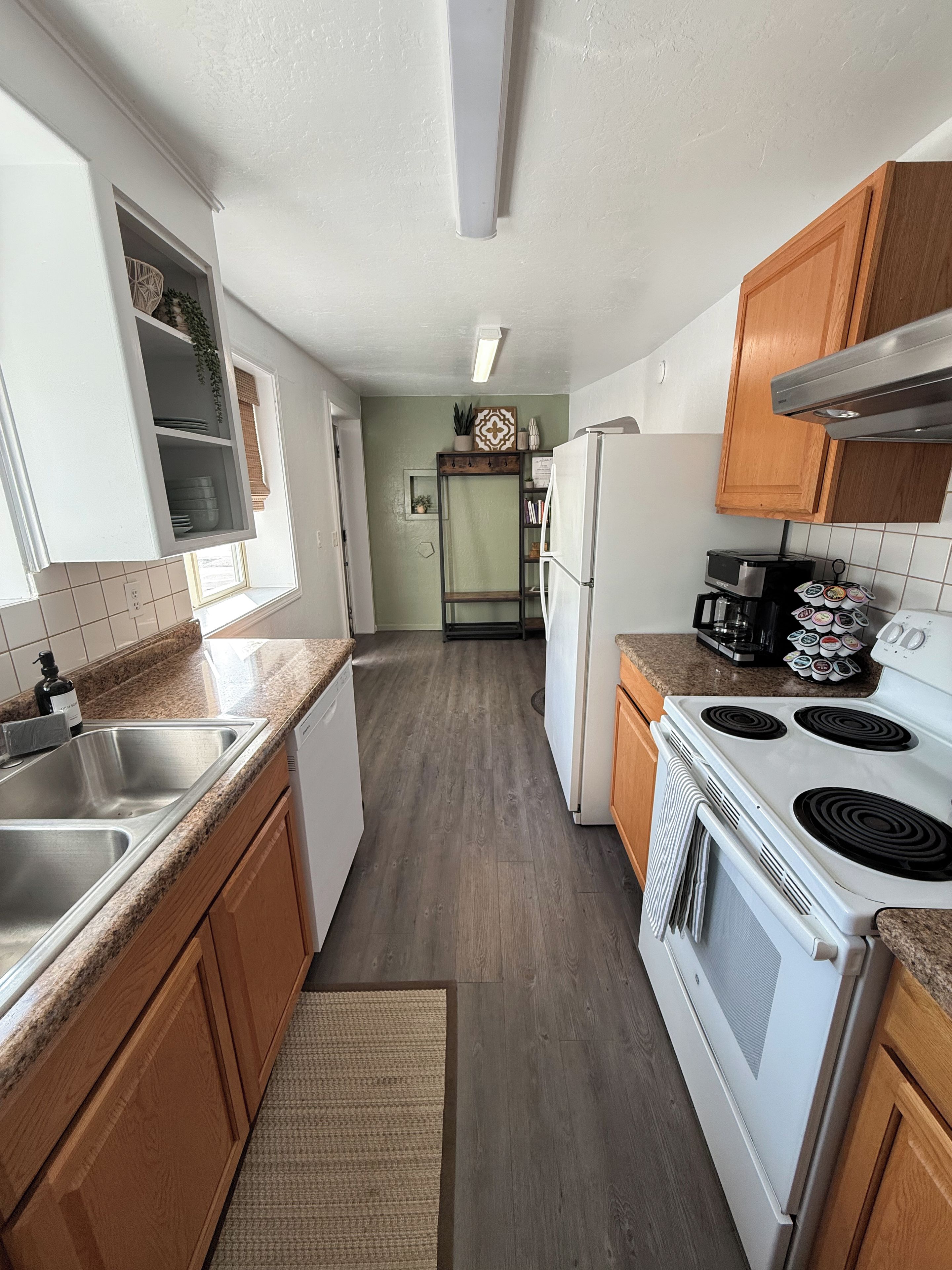 A kitchen with wooden cabinets, a white refrigerator, a stove, and a microwave.