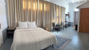 A spacious bedroom with a large bed, a desk, and a chair.