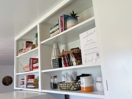 A bookshelf with books, a potted plant, and a sign offering free WiFi and lift ticket discounts.