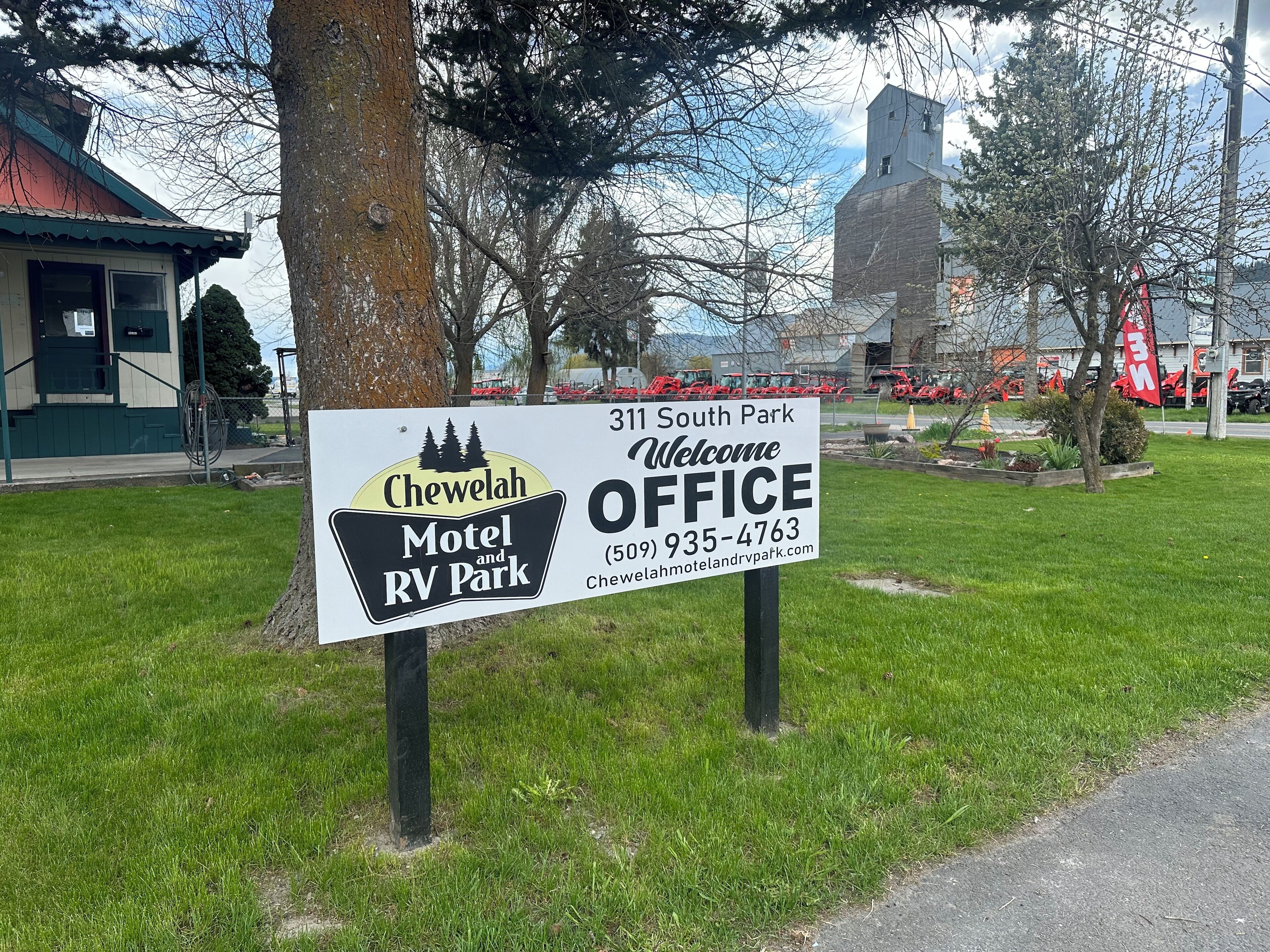 Une enseigne indiquant le « Chewelah Motel and RV Park », situé au 311 South Park, avec une réception accueillante et les coordonnées.