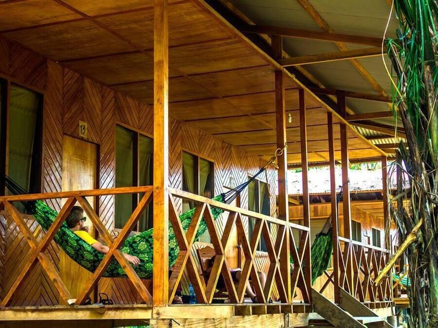 Una estructura de madera con un diseño tipo espiga en las paredes y una barandilla de metal.