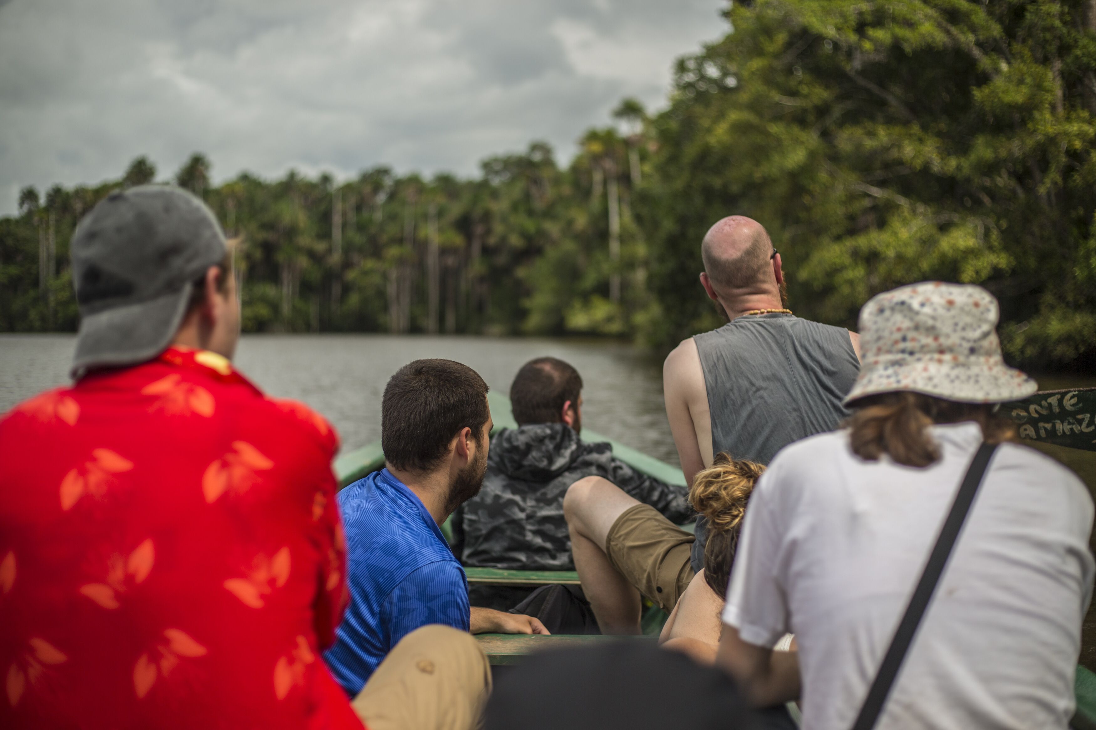 A group of people on a boat, surrounded by water and trees.