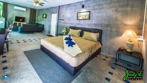 Una habitación de hotel moderna con una cama grande, un escritorio, un televisor y una zona de estar.