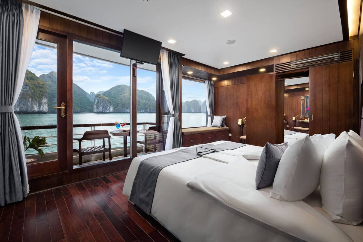 Een slaapkamer met een groot bed, een televisie en uitzicht op het water.