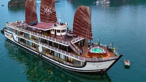 A large river cruise ship with multiple decks, a central dining area, and a hot tub.