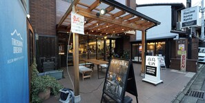 Takashima Brewery's outdoor seating area with a sign for craft beer and a sign indicating the hotel is open. - Racine Home Kyoto SELF CHECK-IN (Kyoto)