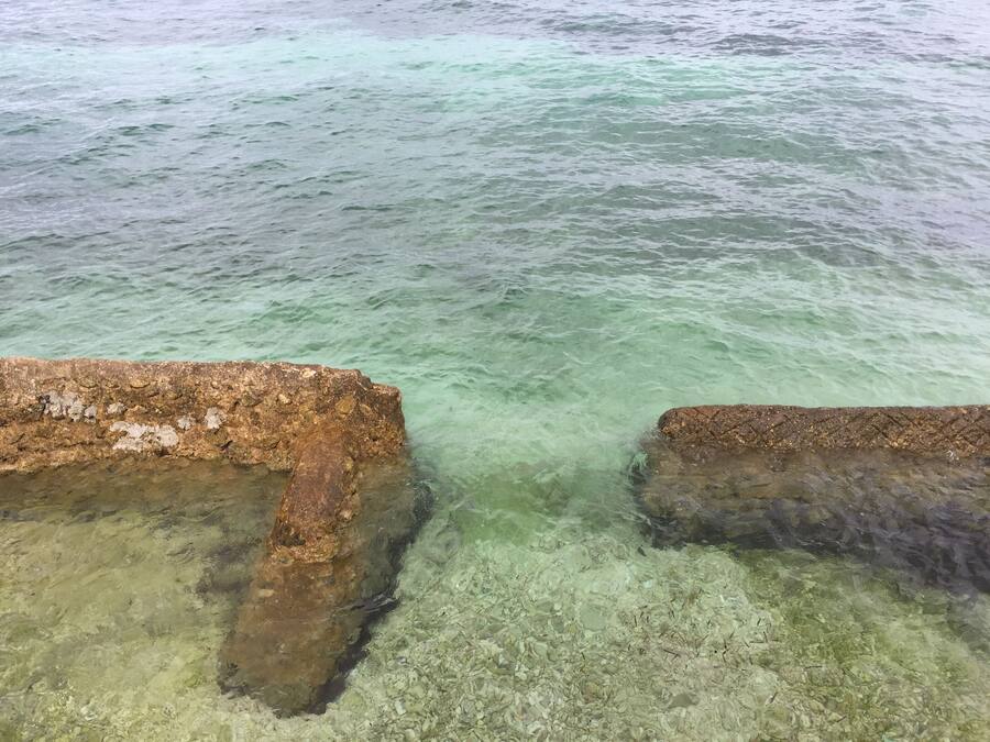 A clear view of a rocky shoreline with shallow water.
