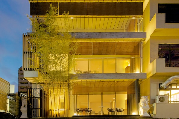 A multi-story building with a modern design, featuring large windows and a balcony.