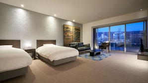 A modern hotel room with two beds, a sofa, a coffee table, and a large window offering a city view. - Aoi Hotel Kyoto (Kyoto)